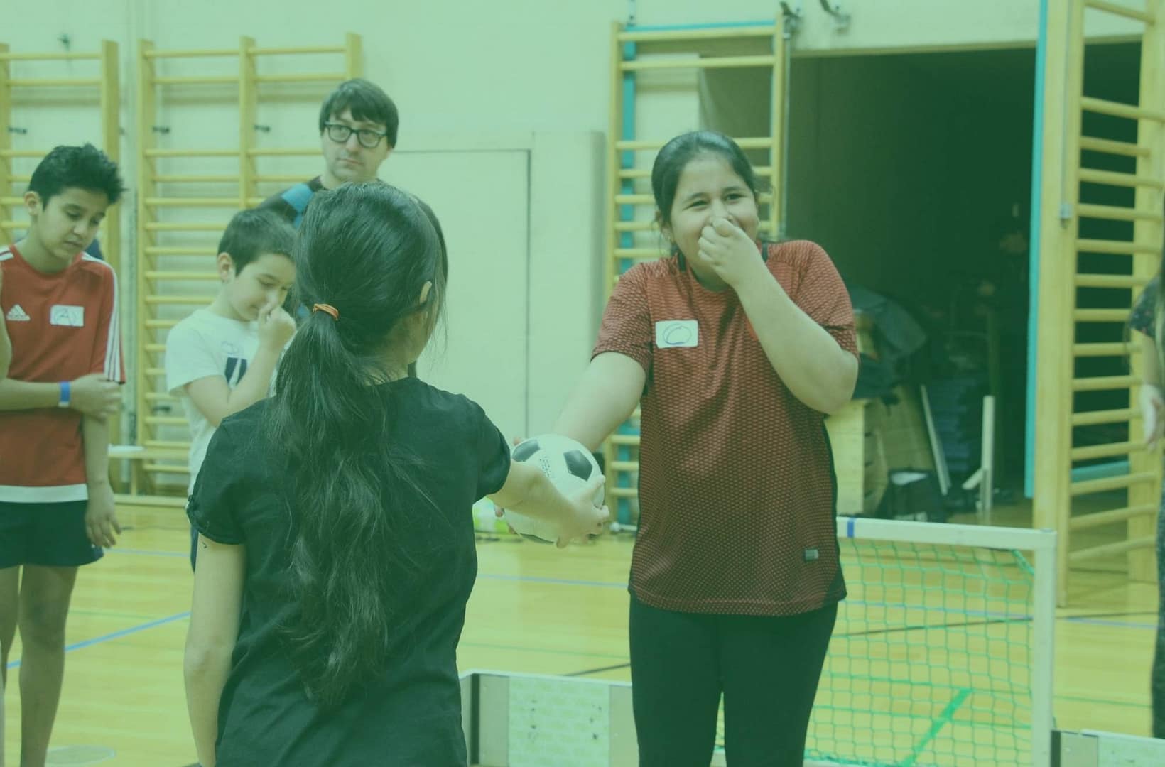 Teamspiel im Freien - vor dem Kick off bei microsoccer, lachendes Mädchen